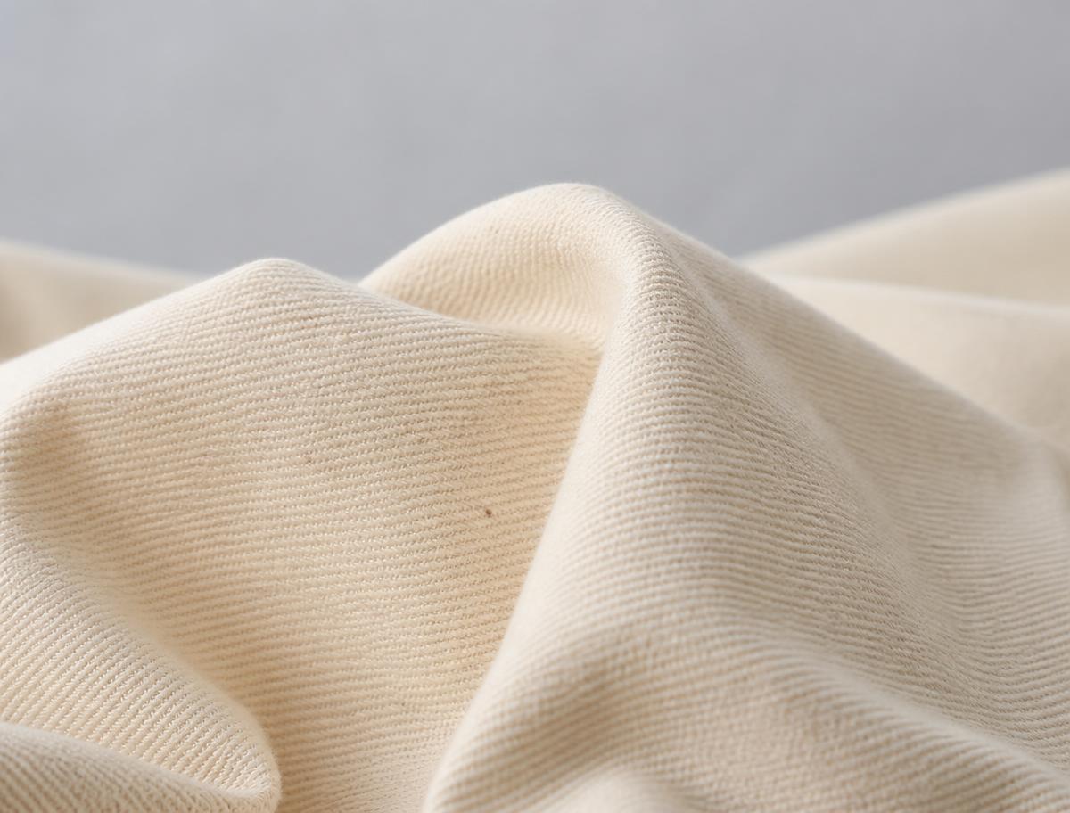 Close-up of natural undyed cotton twill fabric showing cotton fibre texture